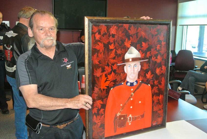 Portraits of Honour artist Dave Sopha unveils a painting of the late RCMP officer Const. Frank Deschenes during a ceremony at the Cumberland detachment on June 21. Deschenes was killed near Memramcook, N.B. last October while helping a motorist change a tire.
