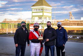 David Dowling won the Paul MacDonald Memorial Driving Championship Saturday at Red Shores at the Charlottetown Driving Park. From left are Prince Edward Island Standardbred Horse Owners Association president Peter Smith, Dowling, Danny and Devon MacDonald, who are Paul MacDonald’s son and grandson, respectively. – Stephanie Mitchell/Red Shores