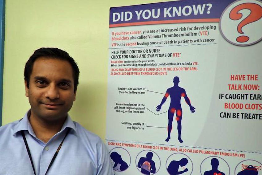 Dr. Sudeep Shivakumar stands beside a blood clot information poster at the Victoria General Hospital on Oct. 15.