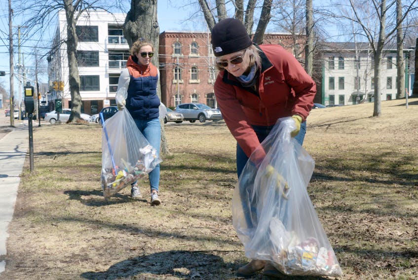 Charlottetown resident Beth Cullen, right, and daughter Clare Cullen clean up some garbage and litter near Province House in Charlottetown on Sunday. More than 30 people, including the Cullens, spent the afternoon taking part in an Earth Day spring cleanup hosted by the non-profit group Fusion Charlottetown. MITCH MACDONALD/THE GUARDIAN