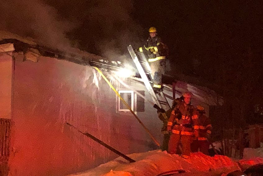 Crews works to put out a fire that extensively damaged a home on Mundy Pond Road near Coefield Street late Thursday evening.
