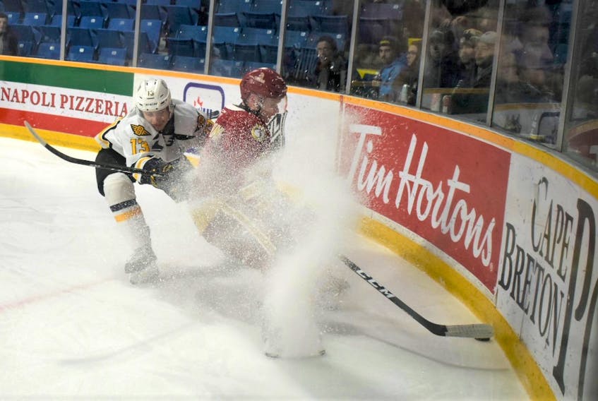 Cole Larkin of the Acadie-Bathurst Titan, right, picks up the puck in the defensive zone as Felix Lafrance of the Cape Breton Eagles pressures during Quebec Major Junior Hockey League action at Centre 200 on Friday. Cape Breton won the game 6-4.