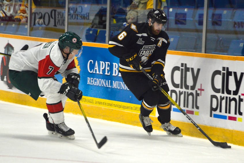 Jarrett Baker of the Cape Breton Eagles, right, skates the puck into the offensive zone as he's pressured by Lucas Robinson of the Halifax Mooseheads during Quebec Major Junior Hockey League action at Centre 200 on Friday. Halifax won the game 6-2.