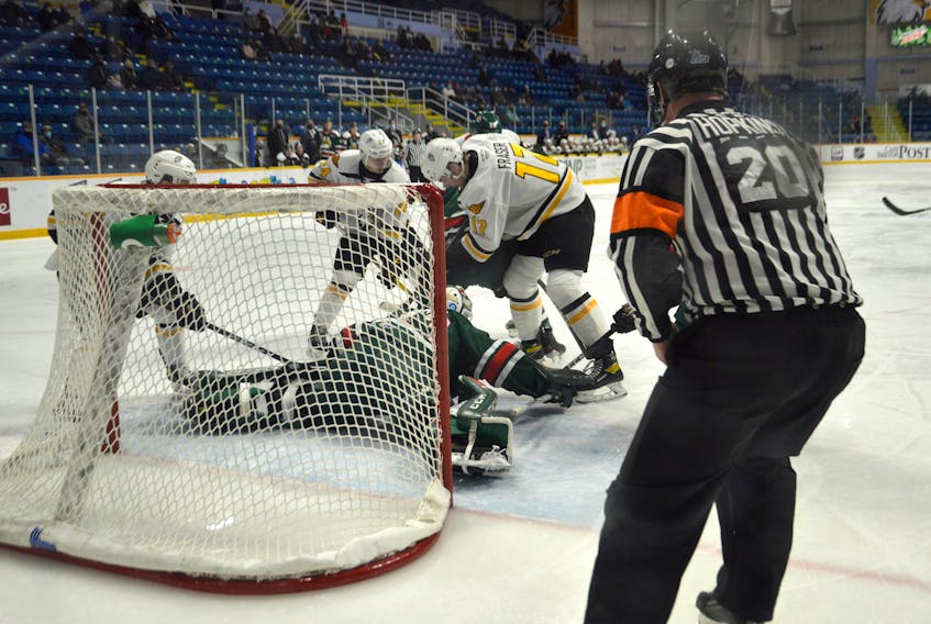 Cole Fraser of the Cape Breton Eagles, middle, bangs away at the loose puck during a scramble in front of the Halifax Mooseheads net in front of goaltender Brady James during Quebec Major Junior Hockey League action at Centre 200 on Friday. Halifax won the game 3-2.