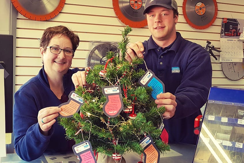 Nancy Crosby and Nathan McCue hope the United Way Giving Trees will help brighten Christmas for some local seniors. They work at Classic Rentals, one of the businesses that hosted a tree.