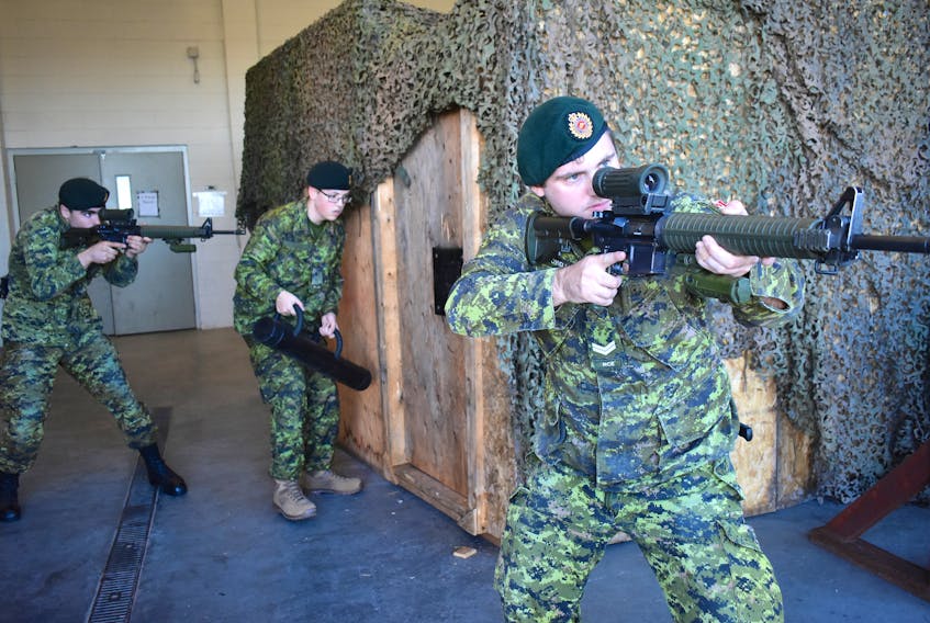 Cpl. Kyle Howell, front, and privates Fred Hamper and Ron Morrison take part in a door breaching exercise Saturday at Victoria Park armouries in Sydney.
