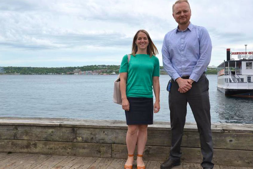 Halifax Regional Municipality climate and environment specialists Shannon Miedema and Alex MacDonald stand by the waterfront on Halifax harbour.