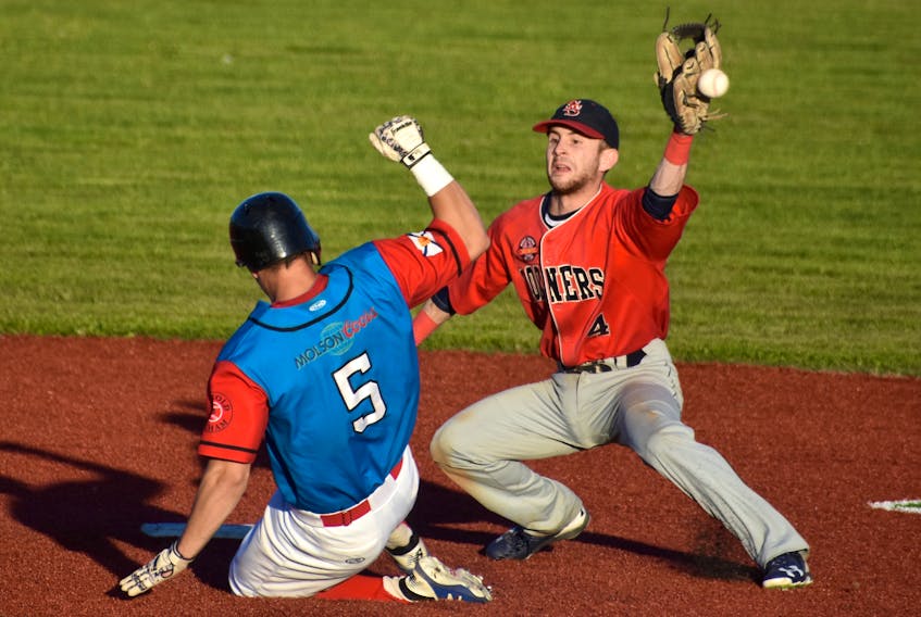 Chris Farrow of the Sydney Sooners, right, misses the throw from the catcher as Greg MacKinnon of the Halifax Pelham Canadians slides safely into second base during Nova Scotia Senior Baseball League action at the Susan McEachern Memorial Ball Park in Sydney, Friday. The Sooners won the game 9-7.