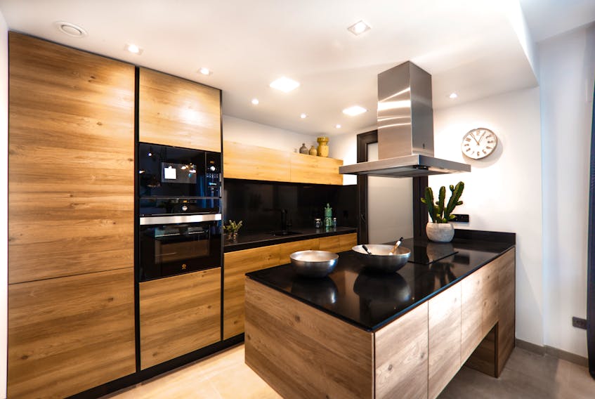 Wooden cabinets and dark countertops are some of the latest kitchen design trends. - Photo Courtesy Ralph Ravi Kayden.