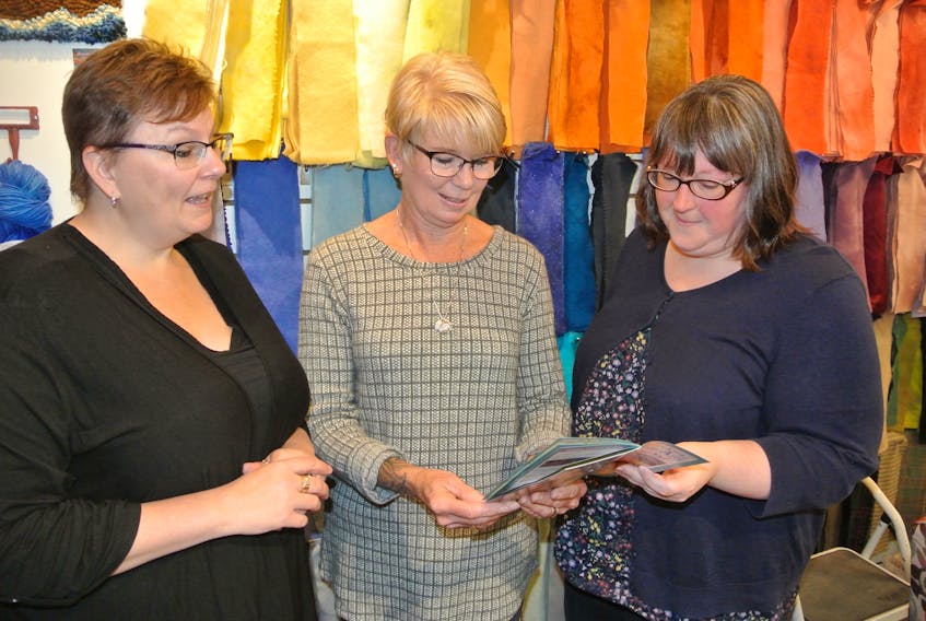 Nova Scotia Fibre Arts Festival chair Denise Corey (left) and board member Chantal Taylor (right) look over a festival brochure with this year’s featured artist Brenda Clarke. The 11th festival runs from Oct. 9 to 13 in Amherst.