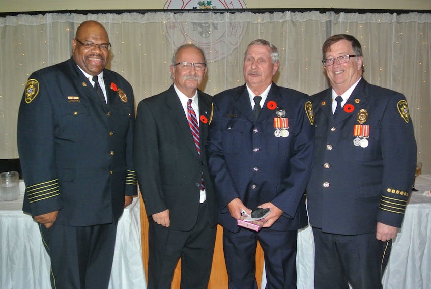 Amherst Fire Chief Greg Jones, Mayor David Kogon and Deputy Chief Brian Farrow present a 40-year service award to Gary Hunter during the department’s 135th anniversary celebration on Nov. 3.