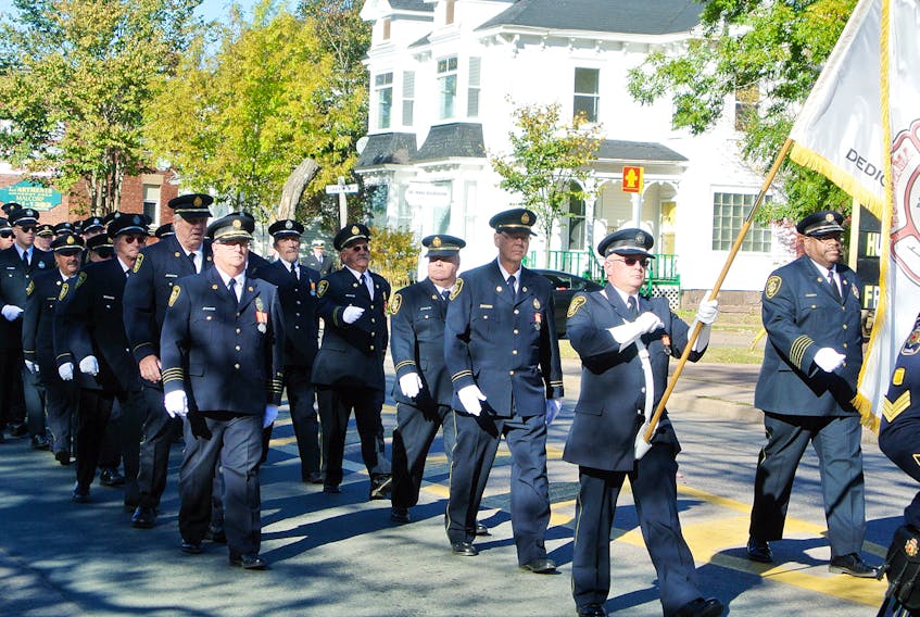 Members of the Amherst Fire Department march back to the fire hall during a memorial service on Sunday that featured a service at First Baptist and the laying of wreaths below the department’s memorial.