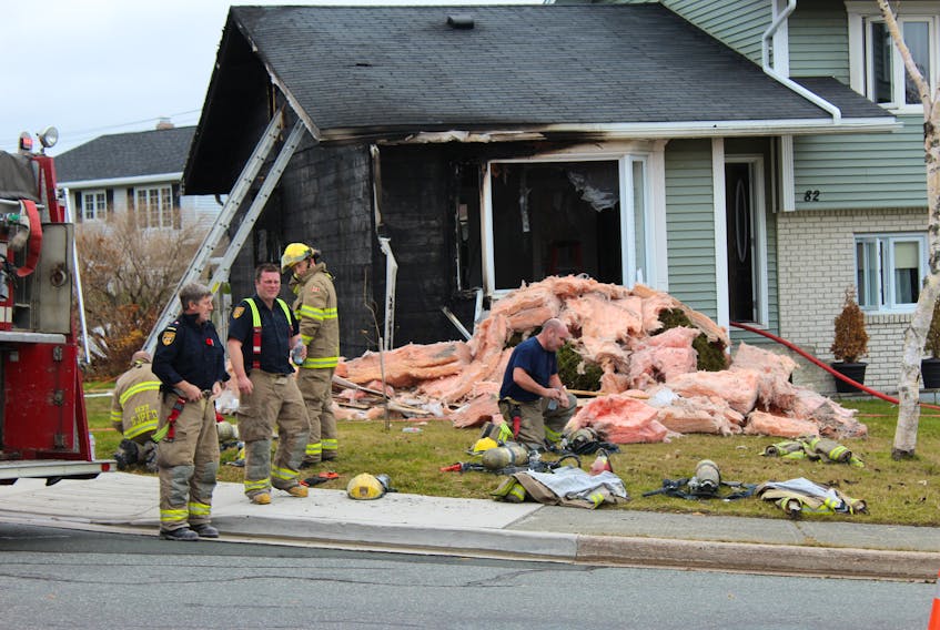 Firefighters work on the house at 82 Carrick Drive in the east end of St. John’s Wednesday morning, hours after a fire gutted a large section of the house. — Photo by Rosie Mullaley/The Telegram