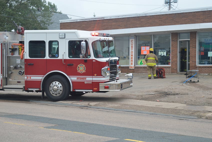 A firefighter watches as crews respond to a washer fire at Vogue Cleaners in Sydney.