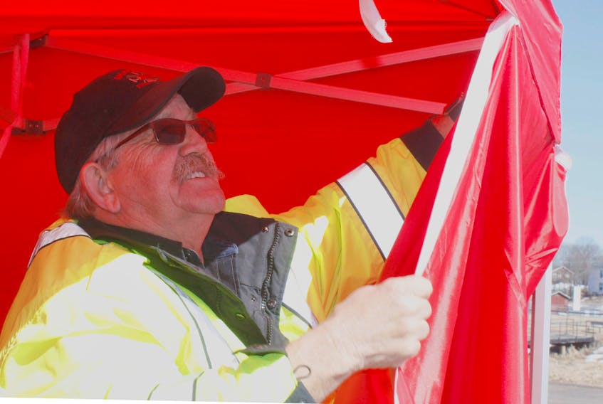 Firefighter Vern Megeney attaches a side panel to the Rehab Tent the Amherst Fire Fighters Ladies Auxiliary recently donated to the department.
