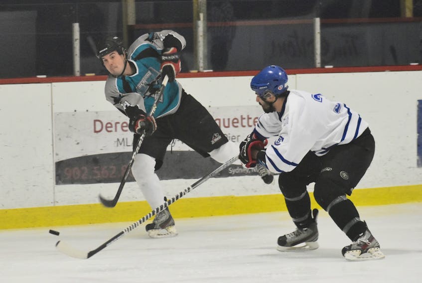 Andrew MacPhee of the Sharks, left, fires a shot on goal as Kailin Paul on the Steelers attempts to block it with his stick during action at the Fitzy Memorial Hockey Tournament at the Whitney Pier Community Rink on Friday. The score result was not available.