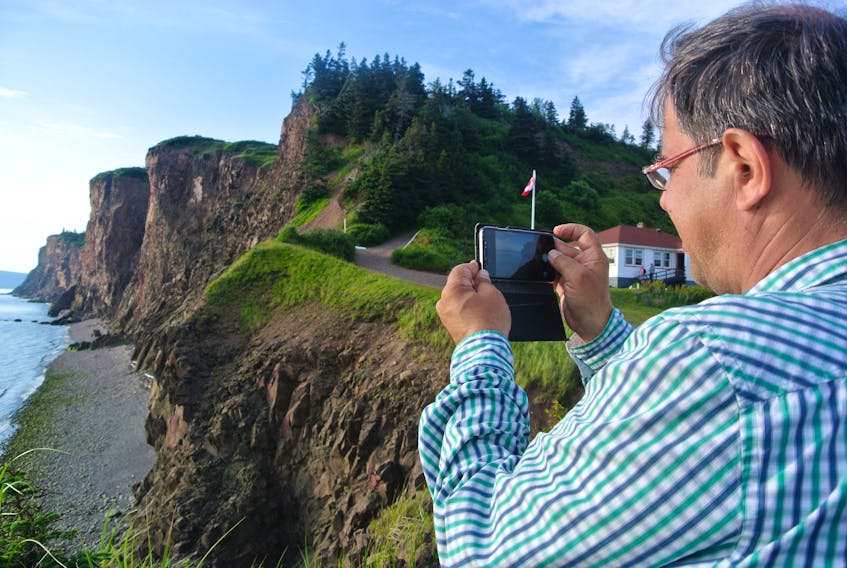 Nikolaos Zouros of Greece snaps of photo of the cliffs at Cape d’Or near Advocate Harbour on Saturday. He and Asier Hilario of the Basque region of Spain were in the region as part of a four-day evaluation of the proposed Cliffs of Fundy Aspiring Global Geopark.