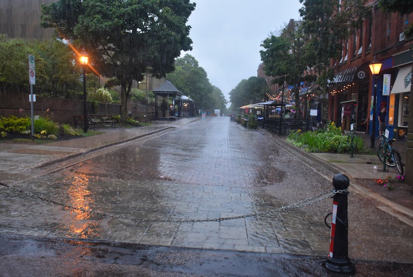 People took shelter on the Victoria Row on Thursday as rain poured down and provided some relief to Prince Edward Island after several heat warnings this summer.