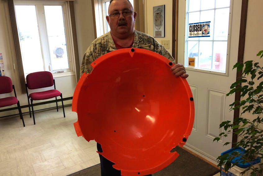 Morgan Short holds half of a large plastic ball that fell off an Emera transmission line during a recent windstorm.