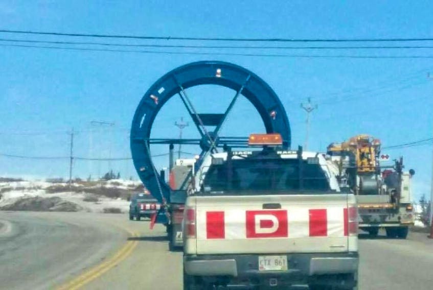 Traffic was halted completely as a Newfoundland Power worker checked that the massive cable reel could safely clear the power lines.