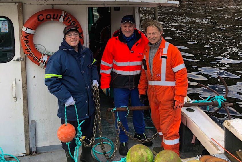 Asle Guneriussen (centre), aquaculture technician from the Norwegian company Akvaplan AS, leads an environmental assessment at a proposed aquaculture site near Burgeo, supported by fisherman Shawn Bowles and Burgeo resident Ken Benoit.