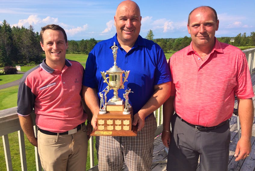 Mark Gould (centre) accepts the Amherst Golf Club men’s championship trophy from club professional Michael Archibald (left) and president Ken Parrell.
