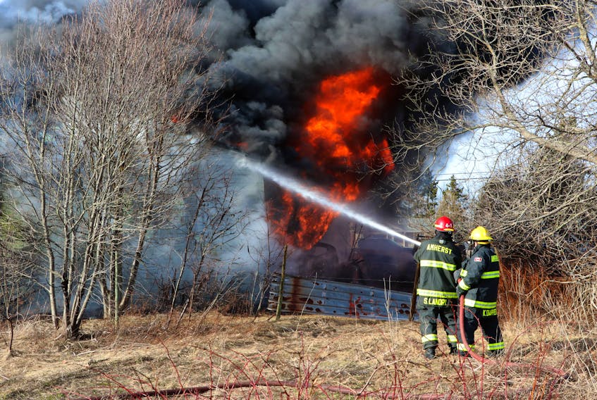 Firefighters battle a blaze on the outskirts of Amherst that destroyed a large garage that contained several vehicles. Tom McCoag/Town of Amherst photo