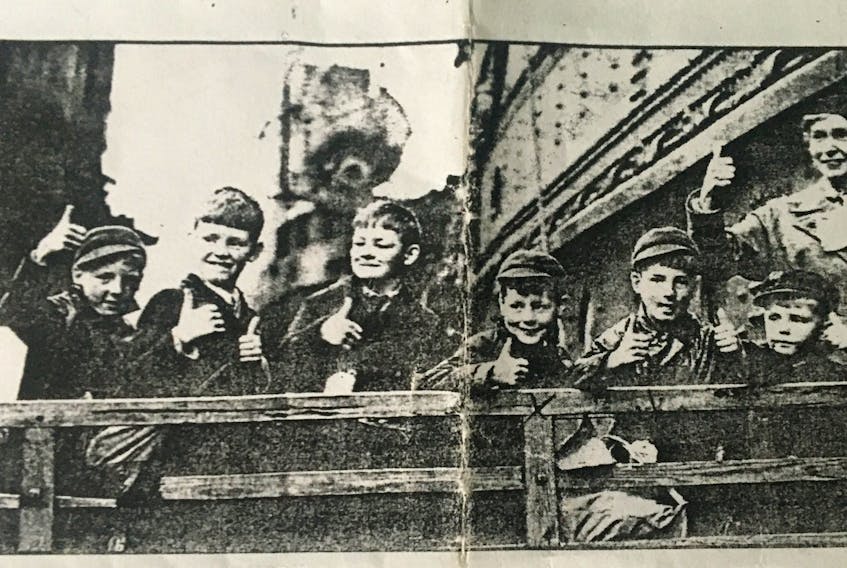 George Thompson, fourth from right, gives the thumbs up preparing to  be evacuated from England to Nova Scotia during the Second World War.