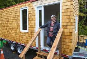 Liam O’Rourke, executive director of Lake City Works, poses for a photo outside a tiny home on Wednesday. Lake City is holding a lottery for the three-season tiny home with the winner being announced in January.