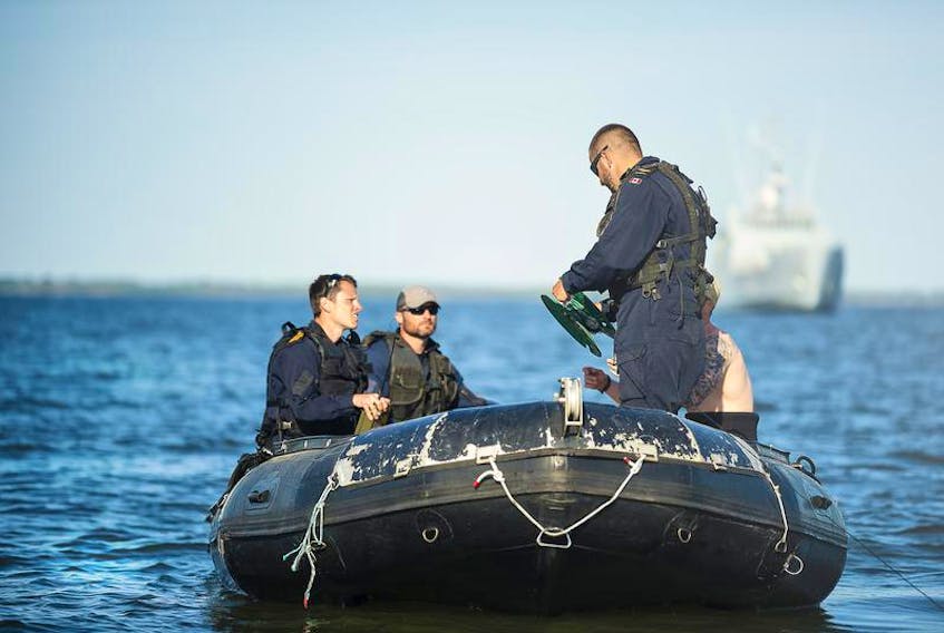 A Royal Canadian Navy clearance diver from the Fleet Diving Unit (Atlantic) reels in detonator cable during Operation OPEN SPIRIT near Muhu Island, Estonia, on May 21. (Corporal Desiree T. Bourdon)