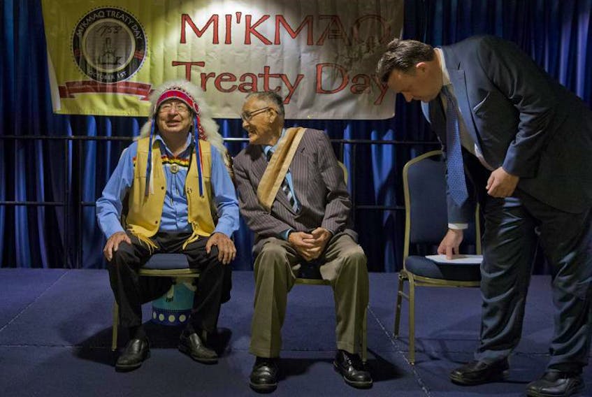 Grand Chief Ben Sylliboy, left, shares a laugh with Wampum belt carrier Victor Alex, as HRM Mayor Michael Savage takes his seat before festivities marking Mi'kmaq Treaty Day at the WTCC in Halifax on Oct. 1, 2015.