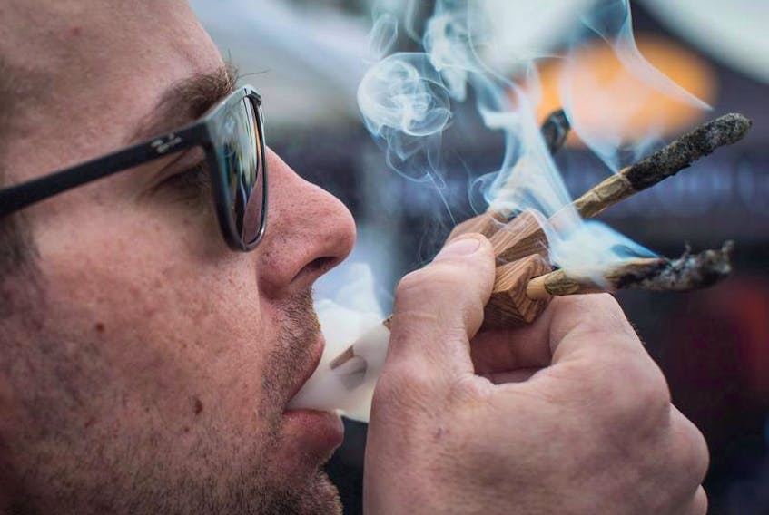 Brandon Bartelds smokes three joints at once while attending the 4-20 annual marijuana celebration, in Vancouver, in April. In less than a month, Canada will become the first industrialized country to legalize recreational marijuana.