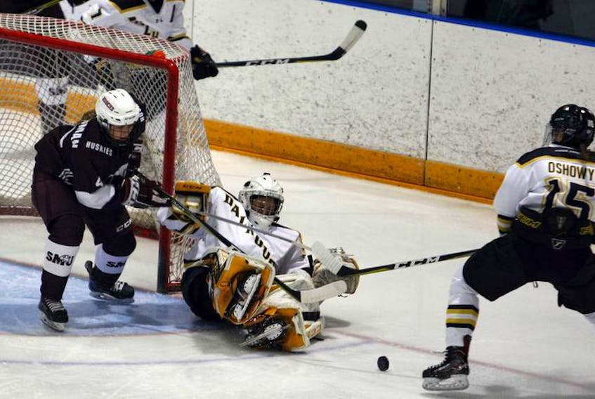 Dalhousie Tigers’ goaltender Fabiana Petricca manages to kick out the puck to teammate Keana Oshowy while Saint Mary’s Huskies’ Leandra Timmerman presses early in the first period of their AUS women’s hockey game at the Halifax Forum on Wednesday.