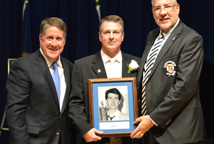 Antigonish native Glenn MacDougall (centre) receives his St. F.X. Sports Hall of Fame plaque from President Kent MacDonald (left) and Director of Athletics and Recreation Leo MacPherson. Paul Hurford