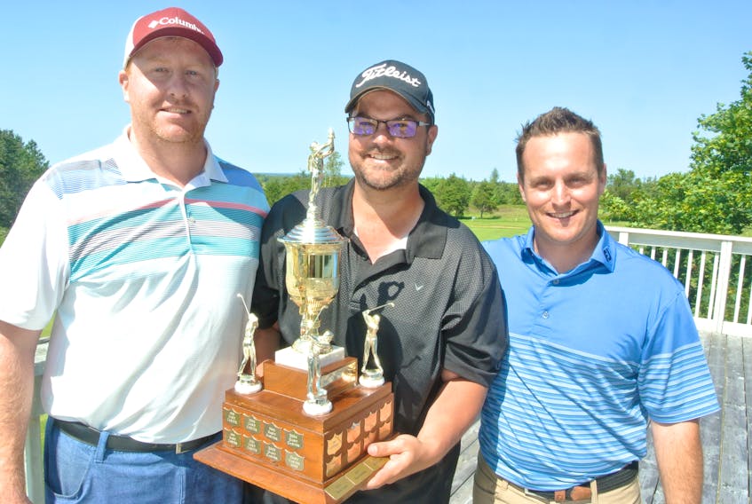 Amherst Golf Club president Cayne Amos (left) and club pro Michael Archibald present the Amherst men’s club championship trophy to Tom Burge, who fired a two-round total of 149 to defeat Matt Cormier by three strokes. Darrell Cole – Amherst News