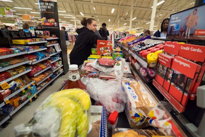 A customer is shown going through the checkout at a local grocery store.