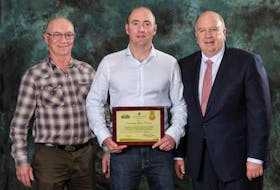 Greg McKenna, left, son Gordon McKenna, with Robert Irving. Gordon was recently recognized for his efforts in sustainable potato farming by Cavendish Farms.