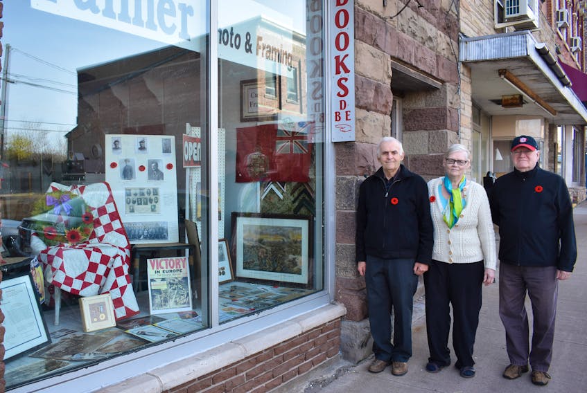 Clyde Macdonald, right, along with Art and Hazel Palmer, owners of Palmer Photo and Framing have compiled artifacts commemorating Canada’s involvement in the First and Second World War in the window of the Palmers’ New Glasgow business. Included are some medals from a relative of Macdonald’s who fought in the war as well as medals that Hazel Palmer’s father earned.