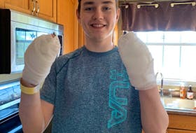 Noah Harrison shows his bandaged hands after taking part in a shoot-a-thon in his grandmother's memory. Harrison shot 1,300 pucks, raising $1,300 in pledges for the Heart and Stroke Foundation.