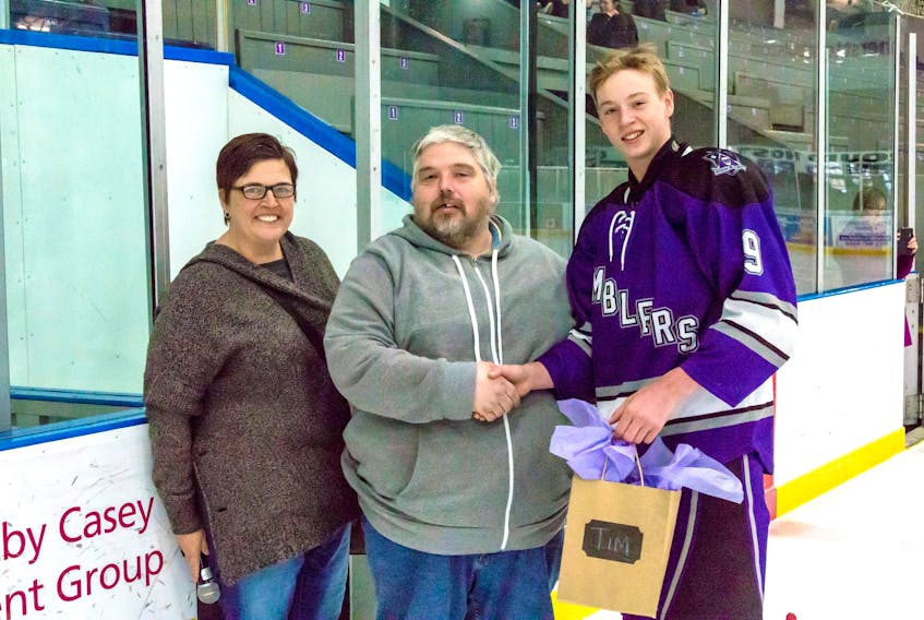 Hockey mom Becky Chitty and hockey player Resse McLean presented Tim Ripley with a gift during their final Midget AA Ramblers game of the season on March 24 at Amherst Stadium.
