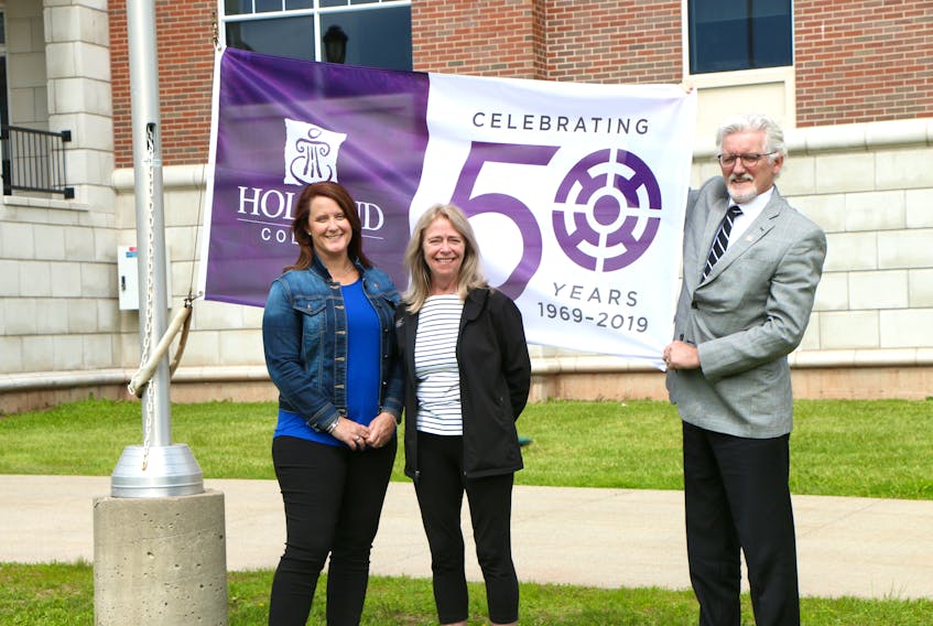 Jennifer Redmond, recruitment co-ordinator, and retired Holland College instructor Twilah Stone join Holland College president Sandy MacDonald for the raising of the college’s 50th anniversary flag.