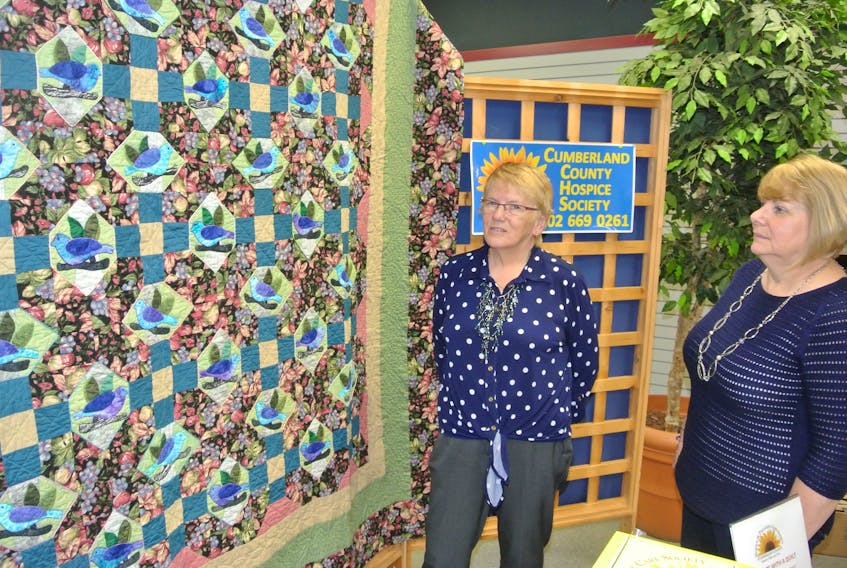 Sandra McSweeney (left) and Laura Hicks, coordinator of the Cumberland County Hospice Palliative Care Society, look over a quilt McSweeney has donated to the society for a year-long draw that will not only raise money for a free-standing hospice facility in Amherst, but will also raise awareness of what hospice is.