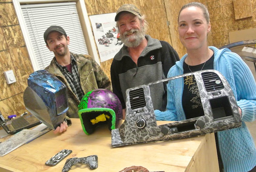 A new home business in the community is customizing everything from automobiles to video game controllers. True Colors Hydrographic’s [from left] Scott Rector, Greg Smith and Jaimie Smith.