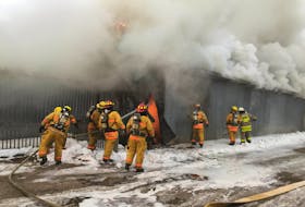 Firefighters work at a burning indoor paintball facility near Canning Saturday morning.
