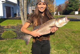 The Chronicle Herald reporter Nicole Munro holds the 80-centimetre striped bass she caught on Oct. 24, 2019.