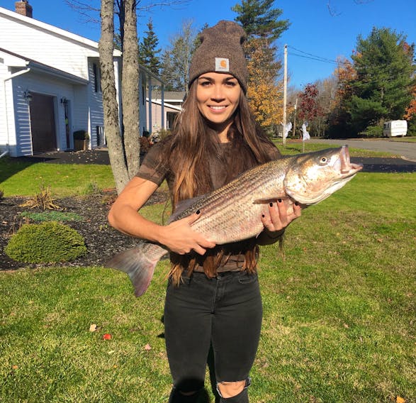 The Chronicle Herald reporter Nicole Munro holds the 80-centimetre striped bass she caught on Oct. 24, 2019.