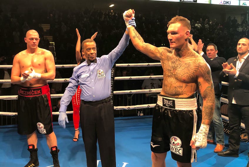 Referee Hubert Earle, middle, holds the arm of Ryan Rozicki, right, following the Sydney Forks boxer successfully defending the WBC International Silver Cruiserweight Championship with a third-round technical knockout win over Czech Republic product Vladimir Reznicek at Centre 200 on Friday.