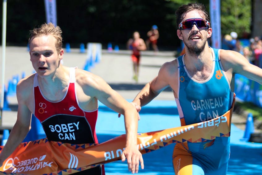 Charlottetown native Martin Sobey, left, crosses the finish line in the Grand Prix final A Saturday in Gatineau, Que. Sobey won the elite division over Quebec’s Edouard Garneau, right, to take the gold medal by two-tenths of a second.