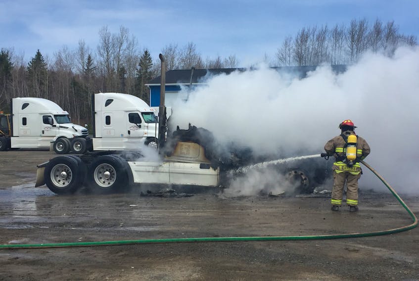 A firefighter works to extinguish a fire at Connors Transfer in Priestville.
