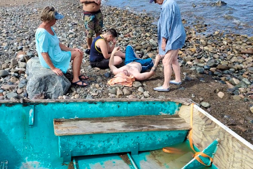 Ruthanna O'Brien sits beside Colin Greene on Jimtown beach, Antigonish County, after the pair were rescued.